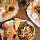 Obfite porcje greckiego jedzenia: gyros, souvlaki, hummus, falafel i pieczywo pita. Smacznego!