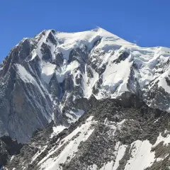 Majestatyczny, ośnieżony szczyt Mont Blanc w Alpach. Widok na masyw górski, gdzie jest Mont Blanc, pod błękitnym niebem.