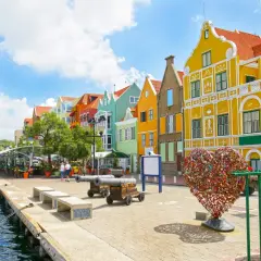 Kolorowe budynki, serce z kłódek i armaty nad wodą – idealne miejsce na curacao wakacje.