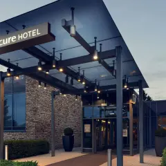 Nowoczesne wejście do hotelu Mercure w Gdańsku, z kamienną fasadą i szklanymi drzwiami.