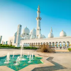 Wielki meczet na Półwyspie Arabskim z fontannami i minaretami w blasku słońca.