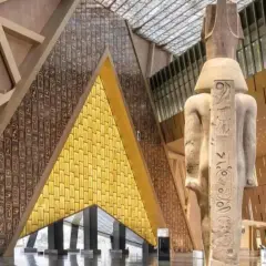 Wielki posąg faraona w nowoczesnym wnętrzu nowego muzeum w Egipcie. Ściany zdobią hieroglify i złote panele.