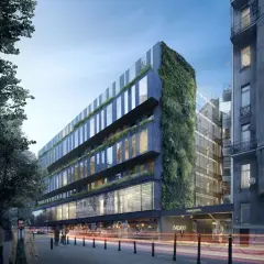 Nowoczesny hotel Nobu Warszawa z zieloną ścianą i przeszklonymi fasadami, otoczony miejską zabudową i drzewami.