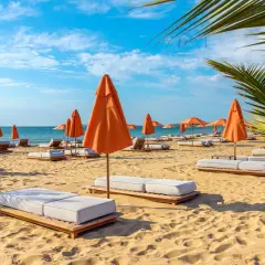 Słoneczna plaża na Złotych Piaskach w Bułgarii. Leżaki i pomarańczowe parasole czekają na turystów, oferując relaks wśród atrakcji kurortu.