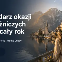 Kobieta w kapeluszu patrzy na malownicze miasteczko nad jeziorem. Dowiedz się, ile jest weekendów w roku i jak je wykorzystać na podróże.