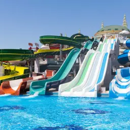 Kolorowe zjeżdżalnie wodne w aquaparku, idealne na turcja wakacje all inclusive.