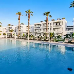 Basen z leżakami i palmami przy hotelu. Idealne miejsce na last minute z Katowic all inclusive.