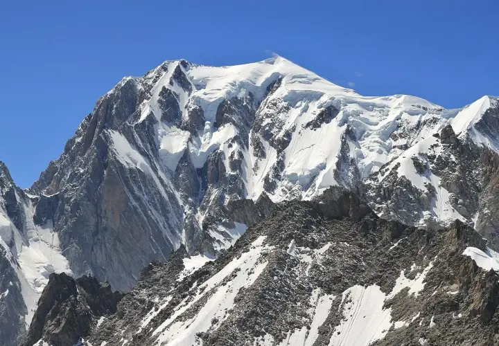 Majestatyczny, ośnieżony szczyt Mont Blanc w Alpach. Widok na masyw górski, gdzie jest Mont Blanc, pod błękitnym niebem.