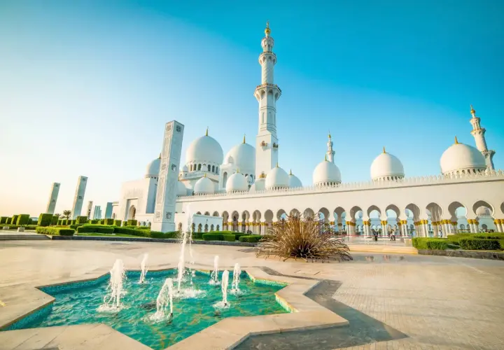 Wielki meczet na Półwyspie Arabskim z fontannami i minaretami w blasku słońca.