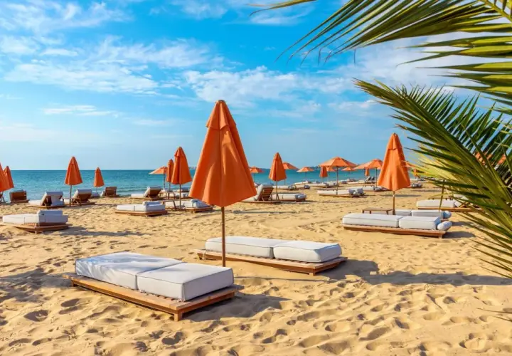 Słoneczna plaża na Złotych Piaskach w Bułgarii. Leżaki i pomarańczowe parasole czekają na turystów, oferując relaks wśród atrakcji kurortu.