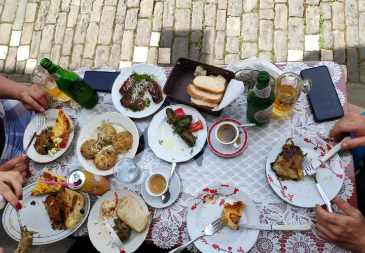 Pyszne albania jedzenie na stole: mięso, gołąbki, pieczywo, kawa i piwo.
