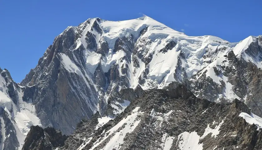 Majestatyczny, ośnieżony szczyt Mont Blanc w Alpach. Widok na masyw górski, gdzie jest Mont Blanc, pod błękitnym niebem.