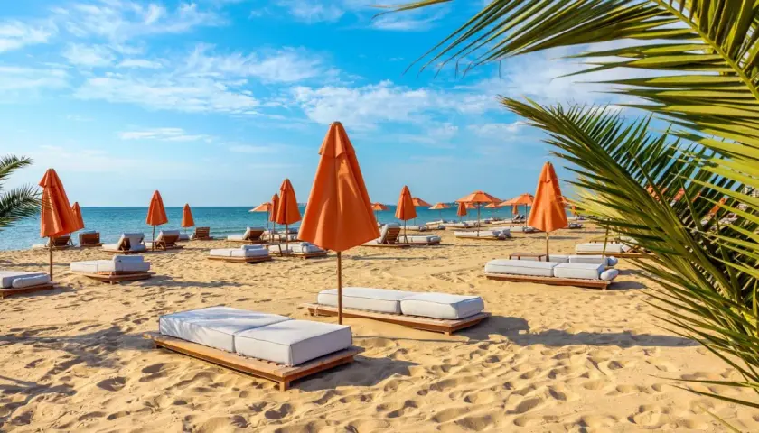 Słoneczna plaża na Złotych Piaskach w Bułgarii. Leżaki i pomarańczowe parasole czekają na turystów, oferując relaks wśród atrakcji kurortu.
