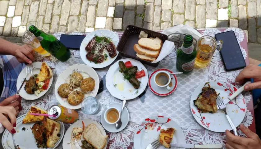 Pyszne albania jedzenie na stole: mięso, gołąbki, pieczywo, kawa i piwo.