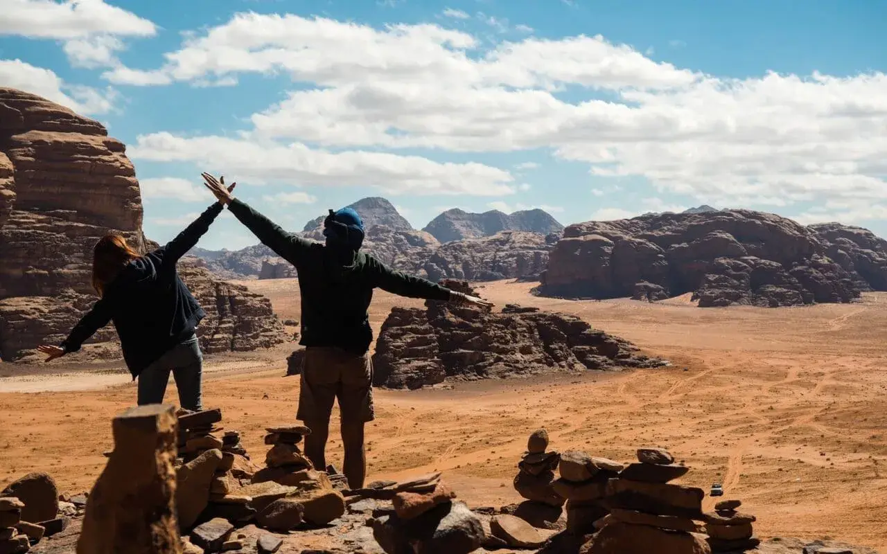 Dwie osoby cieszą się widokiem pustyni Wadi Rum. Odpowiedź na pytanie: czy w Jordanii jest bezpiecznie? Tak, podróżni czują się tu swobodnie.