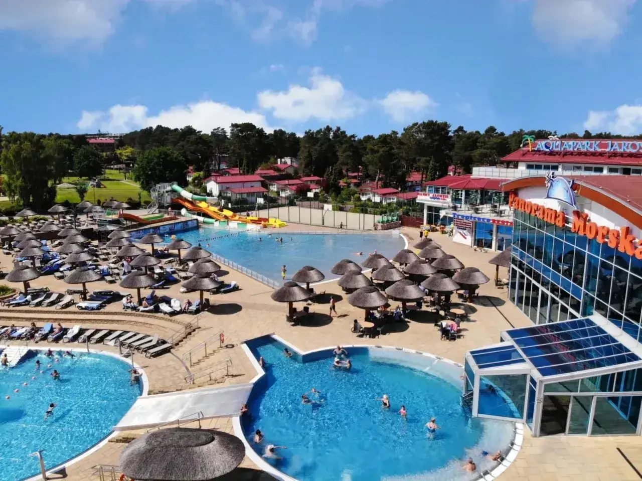 Hotel nad morzem z basenem all inclusive, zjeżdżalniami i mnóstwem leżaków pod parasolami.