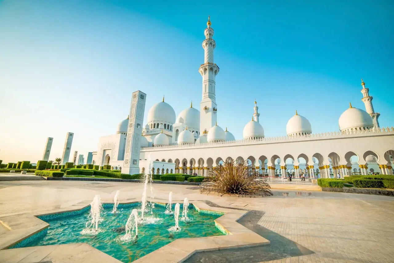 Wielki meczet na Półwyspie Arabskim z fontannami i minaretami w blasku słońca.