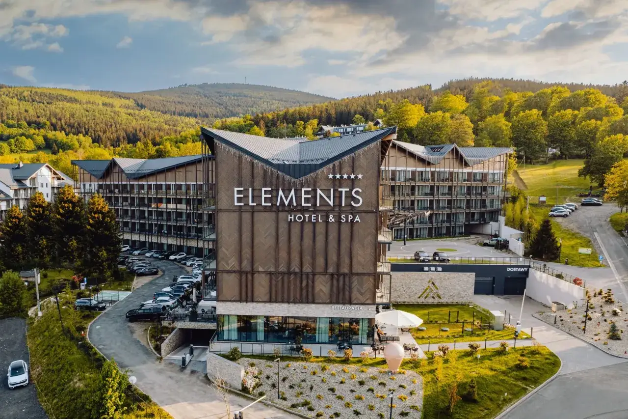 Nowoczesny hotel z animacjami dla dzieci, otoczony zielenią i górami. Idealne miejsce na rodzinne wakacje.