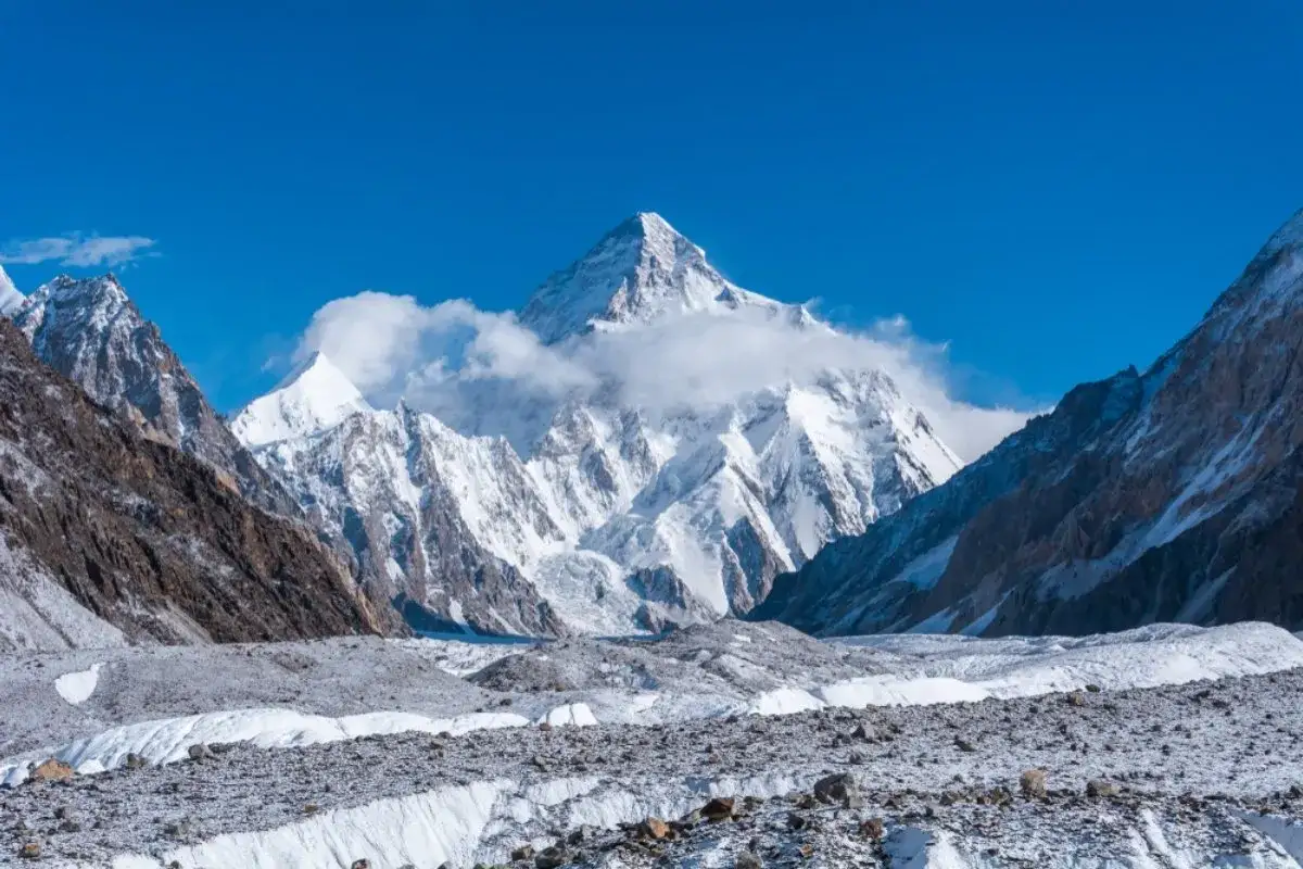 Majestatyczny, pokryty śniegiem najwyższy szczyt Karakorum, K2, góruje nad lodowcem w słoneczny dzień.