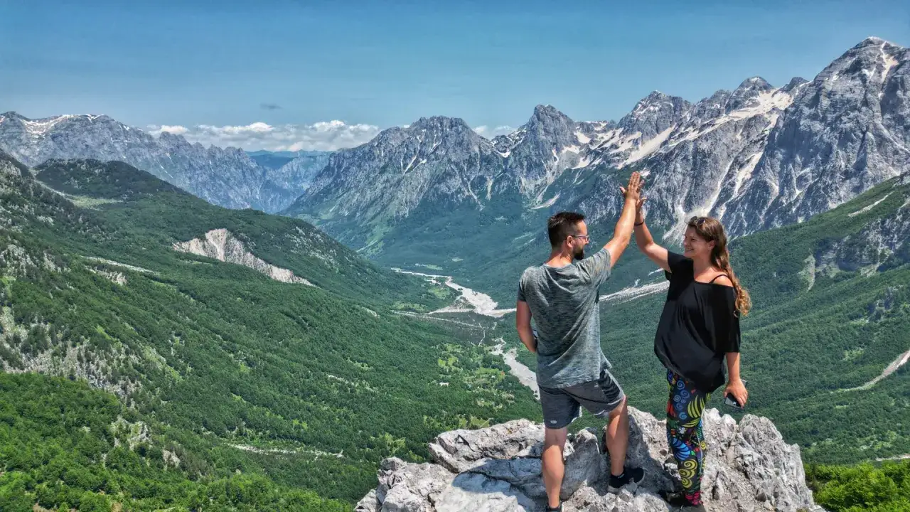 Para świętuje na szczycie, podziwiając majestatyczne albania góry.