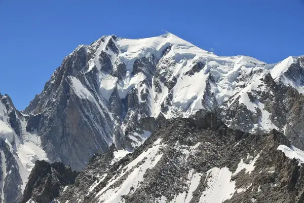 Majestatyczny, ośnieżony szczyt Mont Blanc w Alpach. Widok na masyw górski, gdzie jest Mont Blanc, pod błękitnym niebem.